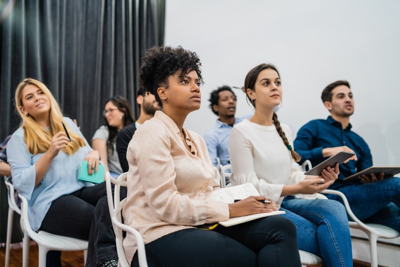 Group of creative business people listening to colleague addressing office meeting. Business and brainstorming concept.